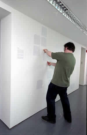fig.1 Chris Reid pasting a text on the wall of the
Atrium in Limerick City Gallery of Art. The texts on the wall were taken from transcripts of
interviews with people Chris met in Limerick City.