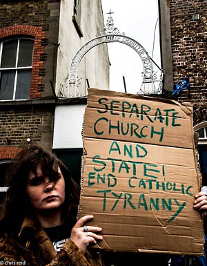 Fig.1 Floe Davis and her placard outside the 'Monastery of our Lady of Charity of Refuge Convent & Magdalene Laundry on Sean McDermott Street, Dublin 1.
